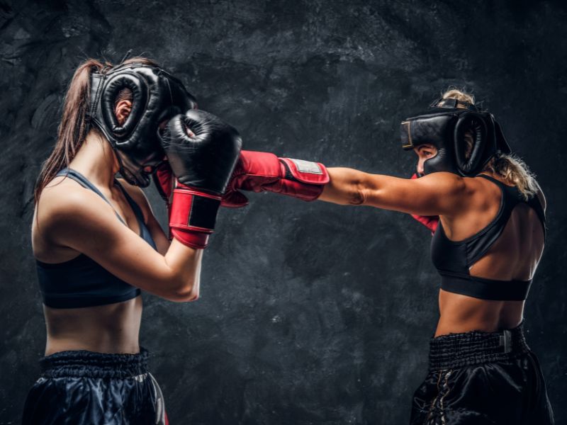 duas garotas em posição de luta, uma aplicando um jab enquanto a outra bloqueia